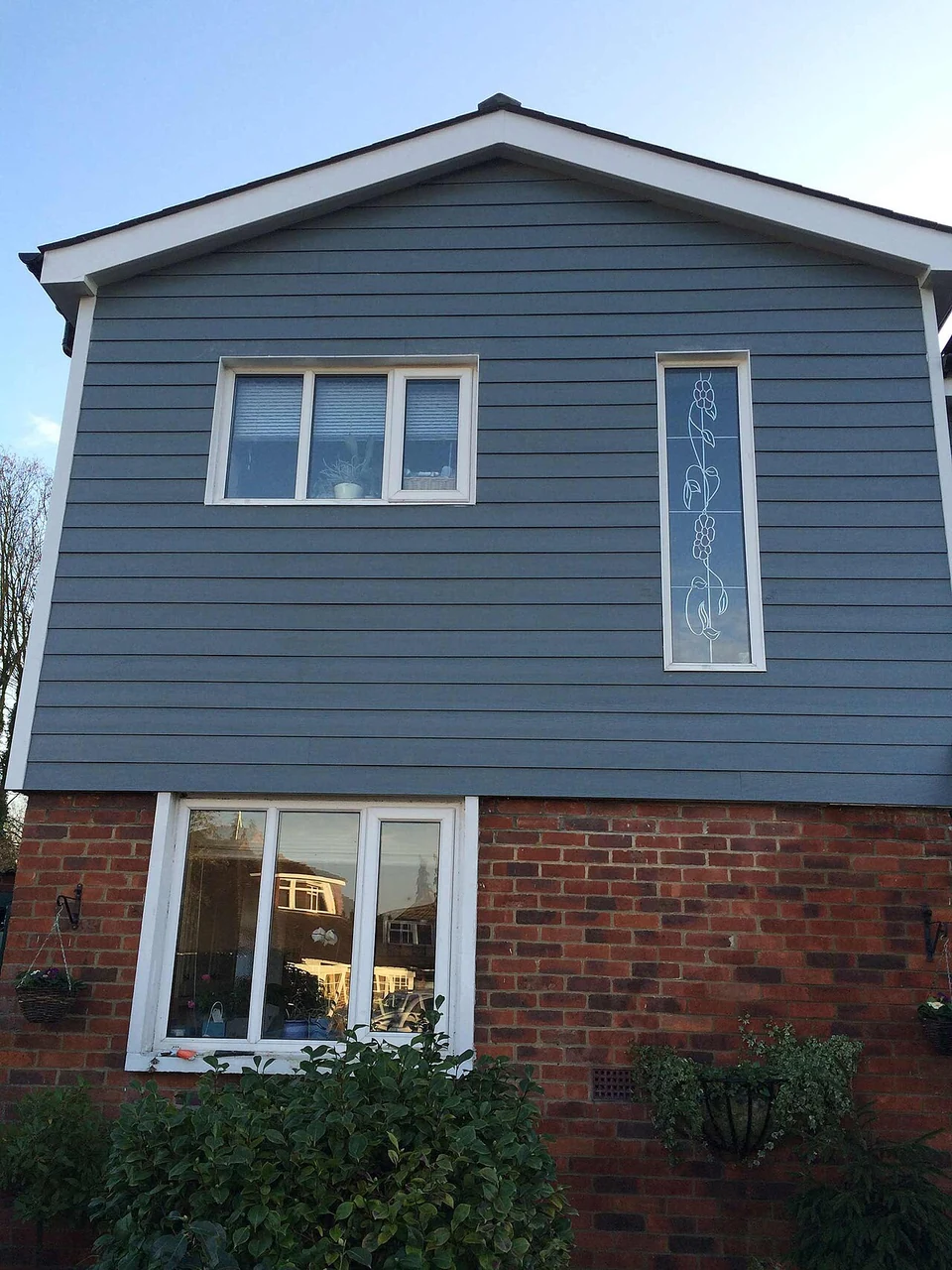 Gutter and downpipe arrangement beside a house exterior